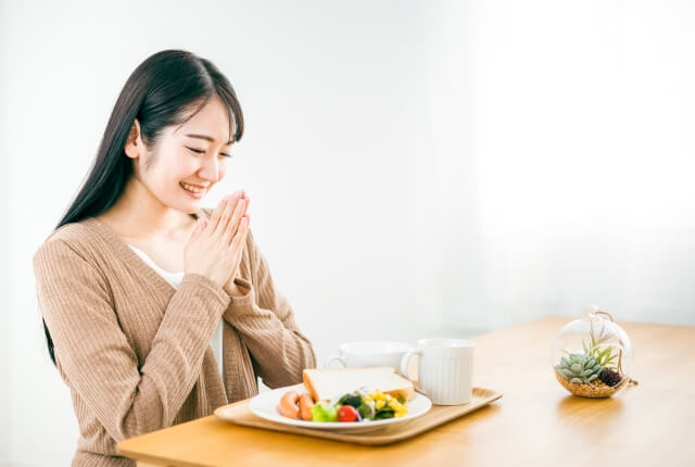朝食を食べる日本人女性（いただきます）