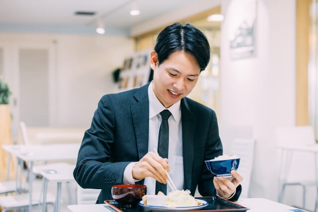 定食を食べる日本人男性ビジネスマン