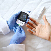 血糖測定器と患者の手
