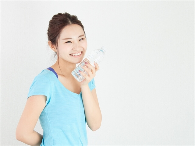 スポーツで水分補給をするアジア人女性