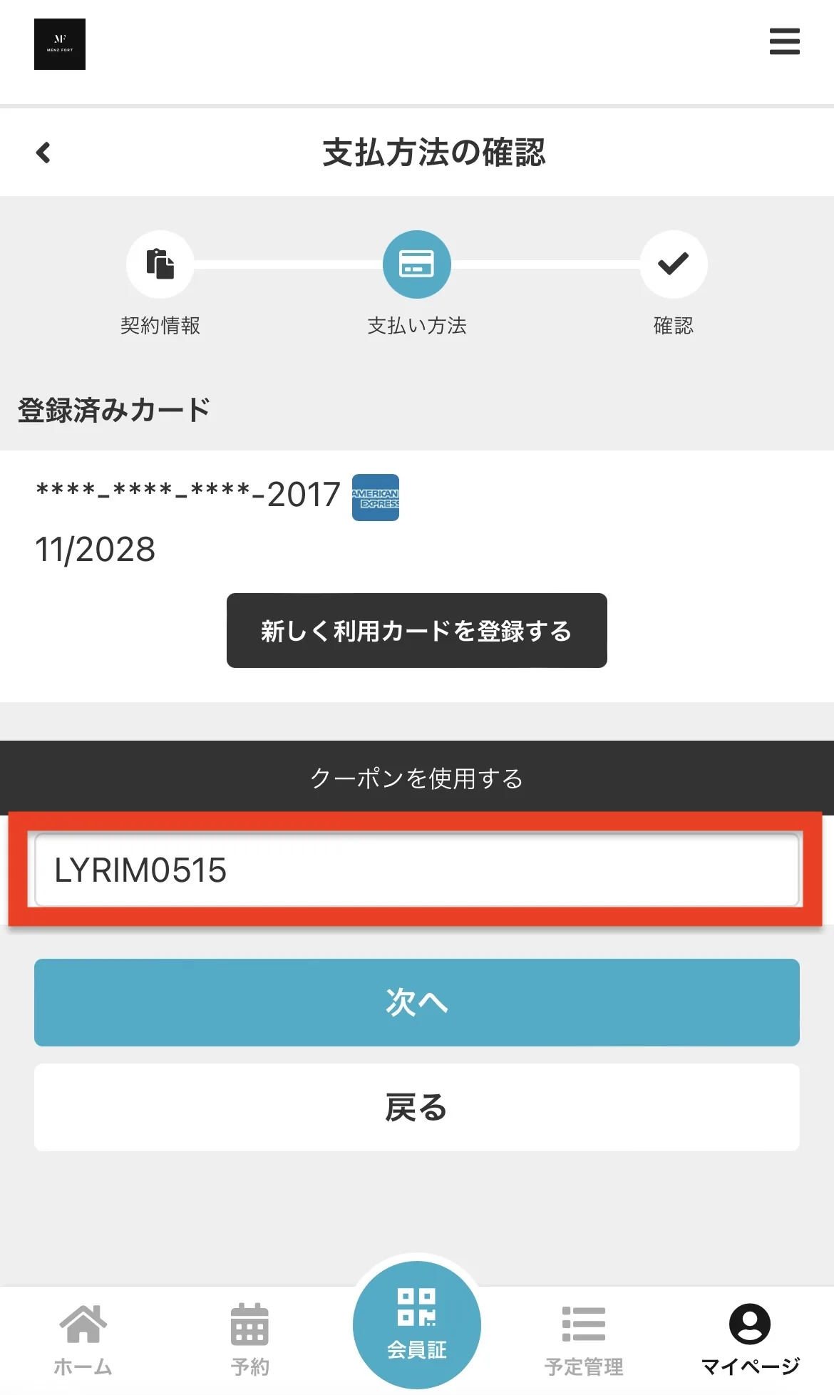 Mobile payment screen in Japanese: shows a masked card ending in 2017, expiration 11/2028, entered code LYRMO515, and a 'Next' button (次へ).